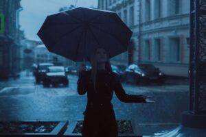 Ragazza con l'ombrello sotto la pioggia