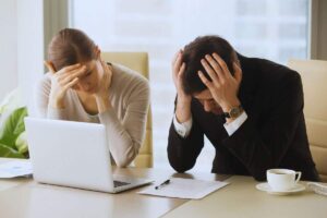 Due dipendenti disperati che si mettono le mani tra i capelli