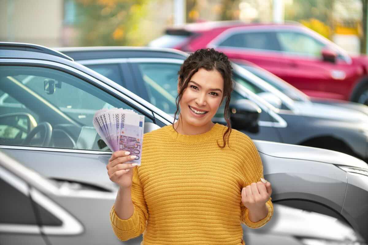 Donna esulta con banconote da 500 euro, sul fondo ci sono delle auto