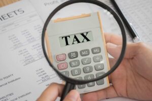 Lente di ingrandimento su calcolatrice con scritto "tax"
