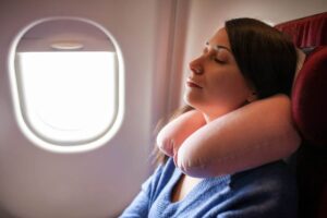 Donna dorme in aereo con cuscino