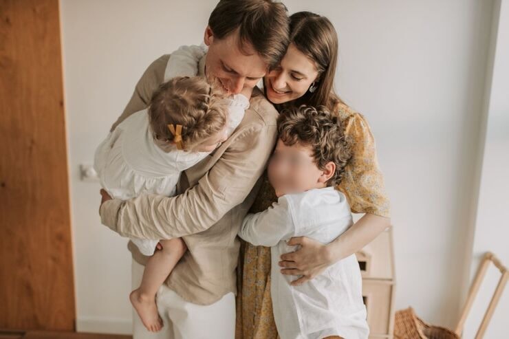 Papà, mamma e due figli si abbracciano