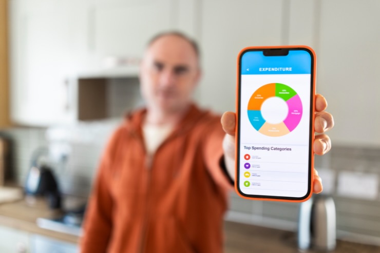 uomo che mostra smartphone con grafico