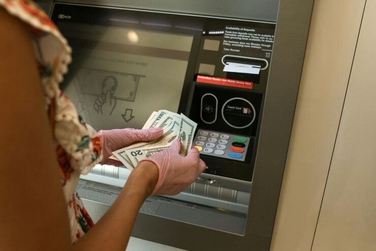 Donna con dollari in mano, al banco ATM 