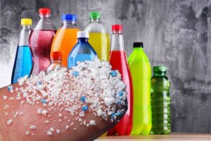 Bottiglie di bevande, dito con microplastiche