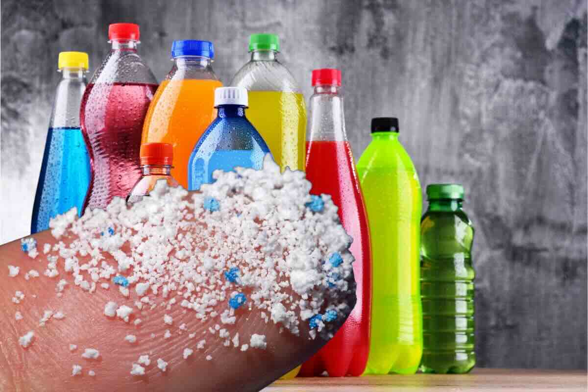 Bottiglie di bevande, dito con microplastiche