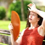 donna che ha caldo con ventaglio