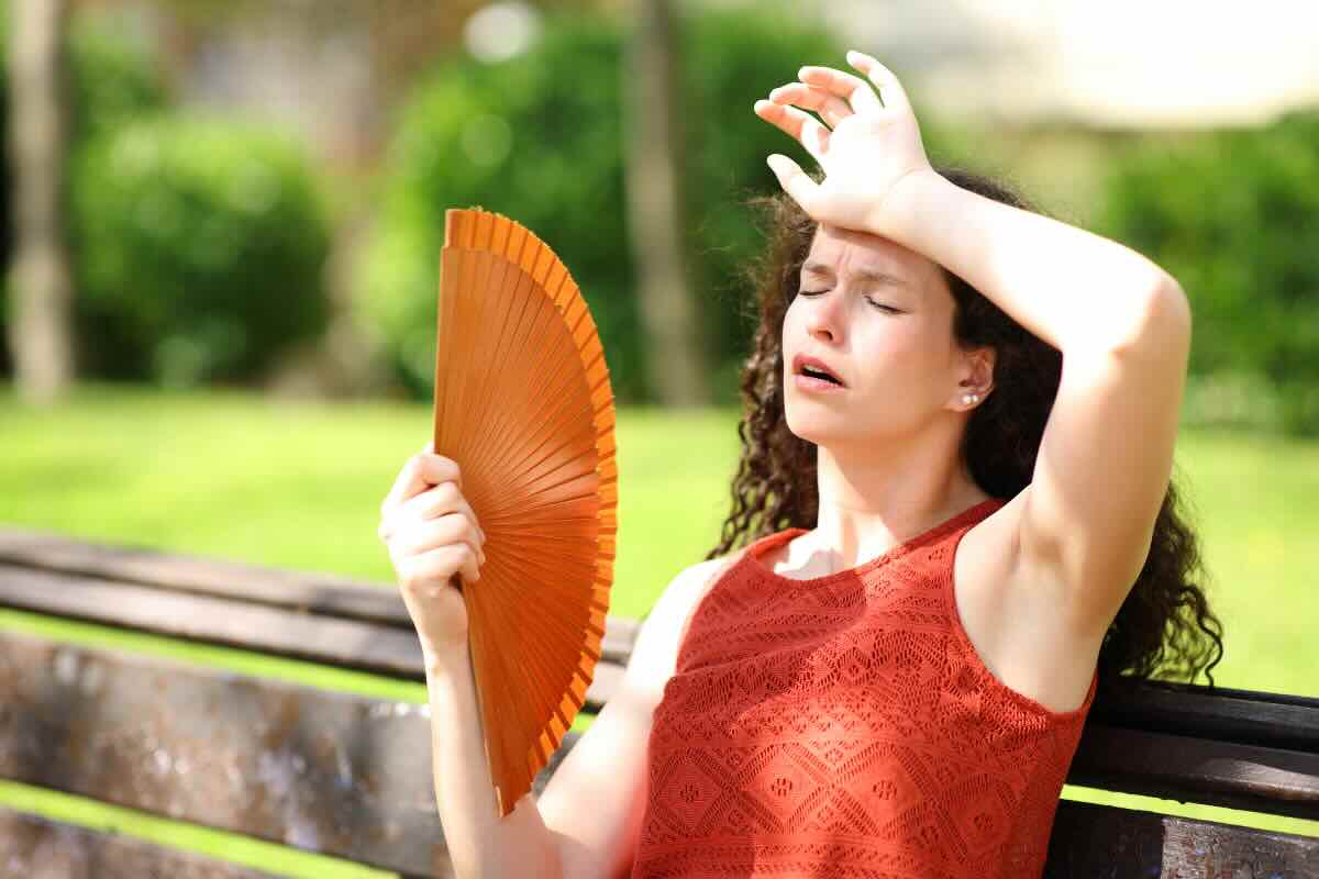 donna che ha caldo con ventaglio