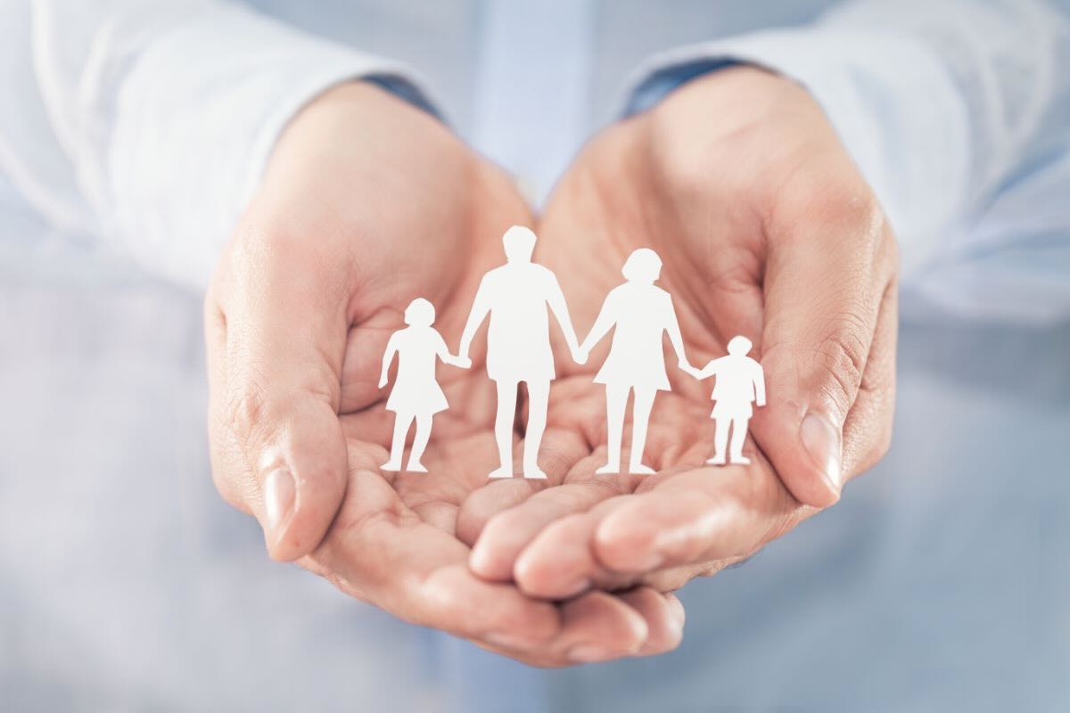 Mano tiene omini di carta rappresentanti famiglia