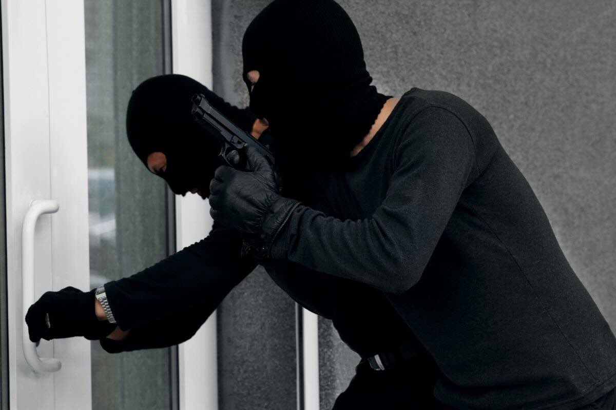 Due ladri stanno scassinando una porta