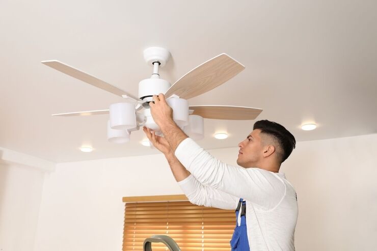 Uomo installa ventilatore a soffitto