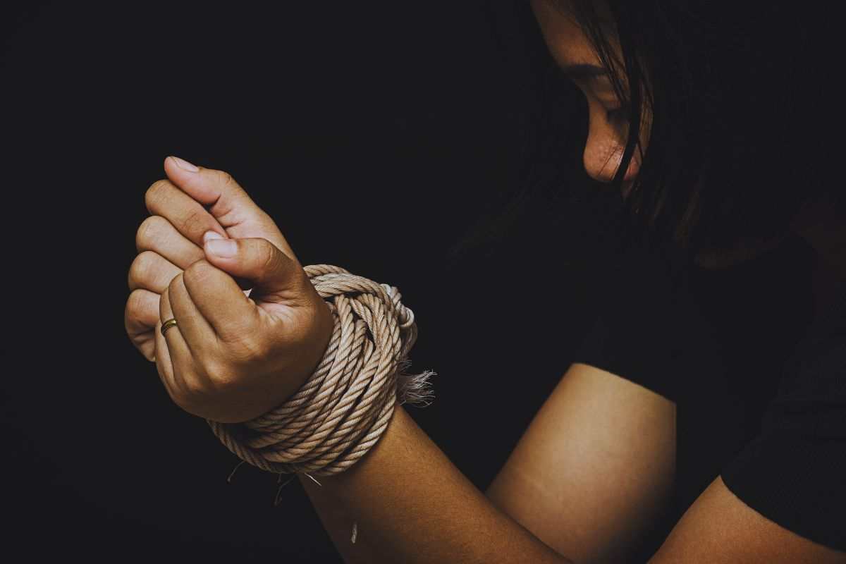 Donna con i polsi legati con una corda