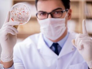 Medico con guanti e provetta con batteri