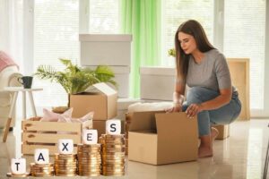 Donna fa scatoloni, monete in scala e scritta "taxes"