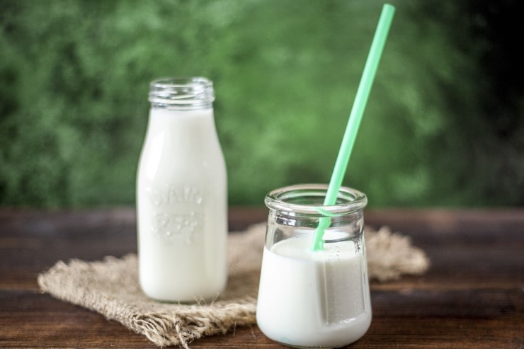 bottiglia di latte e bicchiere di latte con cannuccia