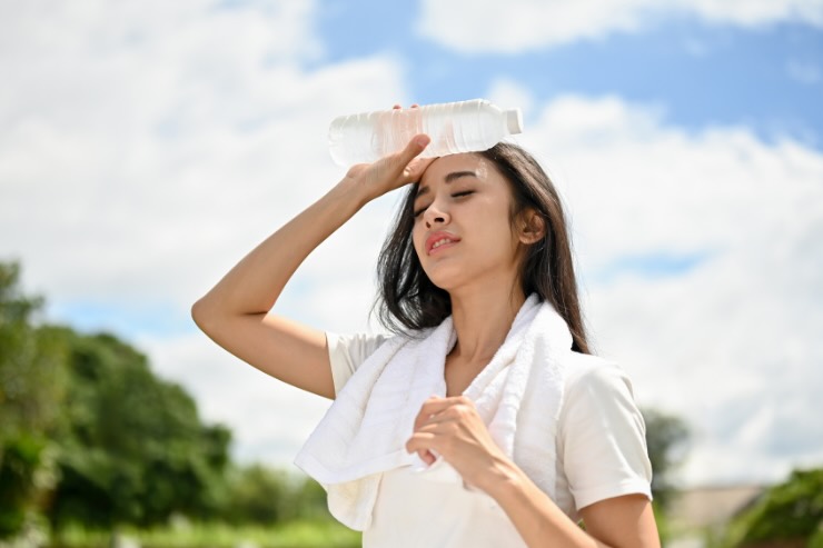 donna che ha caldo con bottiglia in testa